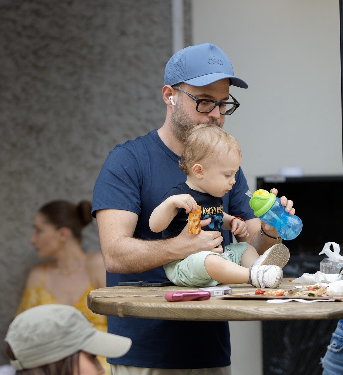 Man feeding baby at high chair